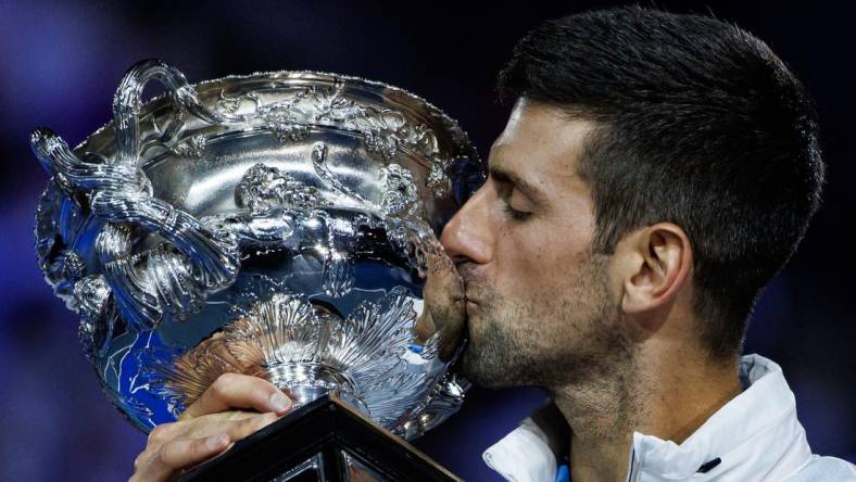 Jan 29, 2023; Melbourne, Victoria, Australia; Novak Djokovic of Serbia celebrates with the trophy after his victory over Stefanos Tsitsipas of Greece in the men's final on day fourteen of the 2023 Australian Open tennis tournament at Melbourne Park. Mandatory Credit: Mike Frey-USA TODAY Sports