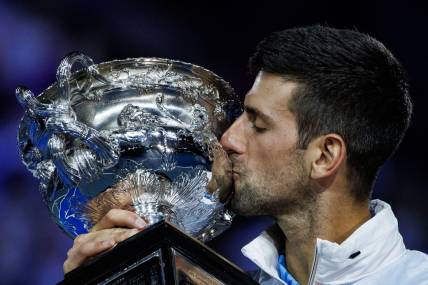 Jan 29, 2023; Melbourne, Victoria, Australia; Novak Djokovic of Serbia celebrates with the trophy after his victory over Stefanos Tsitsipas of Greece in the men's final on day fourteen of the 2023 Australian Open tennis tournament at Melbourne Park. Mandatory Credit: Mike Frey-USA TODAY Sports