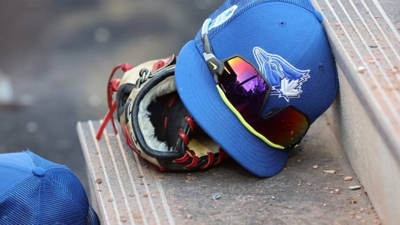 Mar 25, 2023; Dunedin, Florida, USA;  A detail view of Toronto Blue Jays hat and glove against the Detroit Tigers at TD Ballpark. Mandatory Credit: Kim Klement-USA TODAY Sports