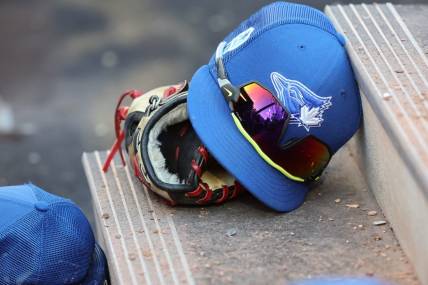 Mar 25, 2023; Dunedin, Florida, USA;  A detail view of Toronto Blue Jays hat and glove against the Detroit Tigers at TD Ballpark. Mandatory Credit: Kim Klement-USA TODAY Sports