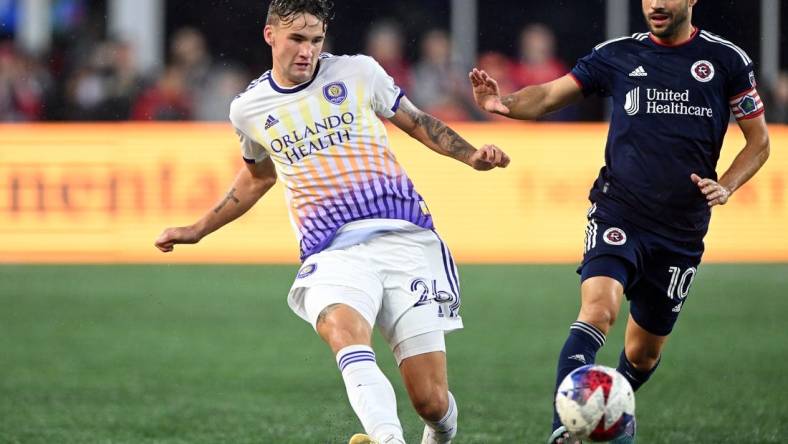 Jun 17, 2023; Foxborough, Massachusetts, USA; Orlando City defender Michael Halliday (26) passes the ball in front of New England Revolution midfielder Carles Gil (10) during the first half of a match at Gillette Stadium. Mandatory Credit: Brian Fluharty-USA TODAY Sports