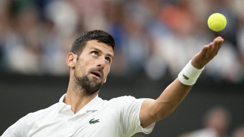 Jul 14, 2023; London, United Kingdom; Novak Djokovic (SRB) tosses the ball to serve during his match against Jannik Sinner (ITA) on day 12 at the All England Lawn Tennis and Croquet Club.  Mandatory Credit: Susan Mullane-USA TODAY Sports