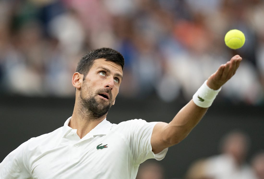 Jul 14, 2023; London, United Kingdom; Novak Djokovic (SRB) tosses the ball to serve during his match against Jannik Sinner (ITA) on day 12 at the All England Lawn Tennis and Croquet Club.  Mandatory Credit: Susan Mullane-USA TODAY Sports