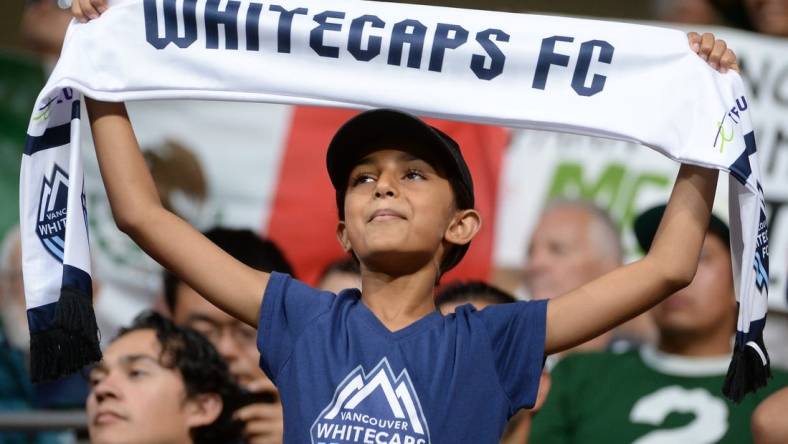 Jul 21, 2023; Vancouver, British Columbia, CAN; A young Vancouver Whitecaps fan is seen holding a scarf during the second half between the Vancouver Whitecaps and Club Leon at BC Place. Mandatory Credit: Anne-Marie Sorvin-USA TODAY Sports