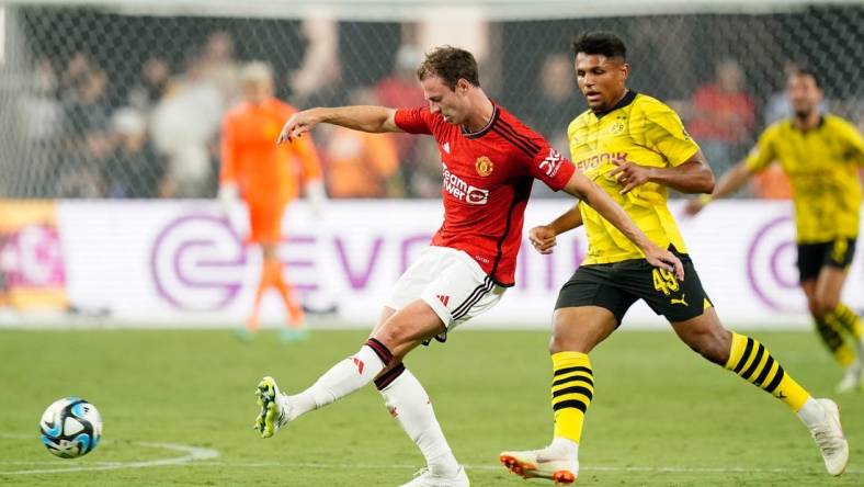 Jul 30, 2023; Las Vegas, Nevada, USA; Manchester United defender Jonny Evans (27) kicks the ball against Borussia Dortmund forward Paul-Phillip Besong (49) during the second half at Allegiant Stadium. Mandatory Credit: Lucas Peltier-USA TODAY Sports