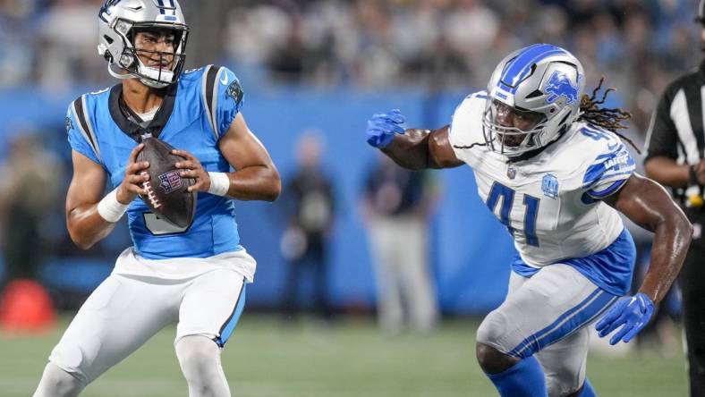 Aug 25, 2023; Charlotte, North Carolina, USA; Carolina Panthers quarterback Bryce Young (9) drops back under pressure from Detroit Lions linebacker James Houston (41) during the first quarter at Bank of America Stadium. Mandatory Credit: Jim Dedmon-USA TODAY Sports