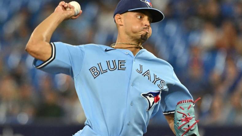 Aug 28, 2023; Toronto, Ontario, CAN;  Toronto Blue Jays relief pitcher Jordan Hicks (12) delivers a pitch against the Washington Nationals in the ninth inning at Rogers Centre. Mandatory Credit: Dan Hamilton-USA TODAY Sports