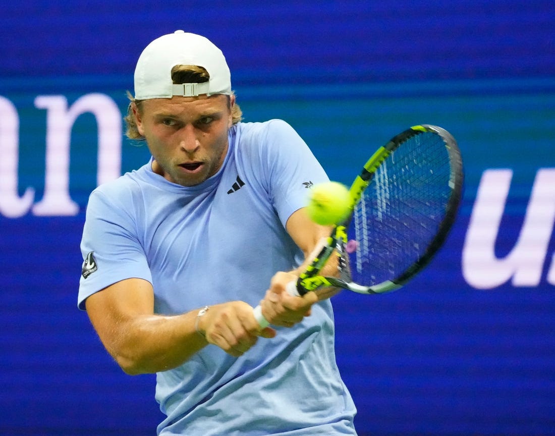 Aug 28, 2023; Flushing, NY, USA;  
Alexandre Muller of France hits to Novak Djokovic of Serbia on day one of the 2023 U.S. Open tennis tournament at USTA Billie Jean King National Tennis Center.
Mandatory Credit: Robert Deutsch-USA TODAY Sports