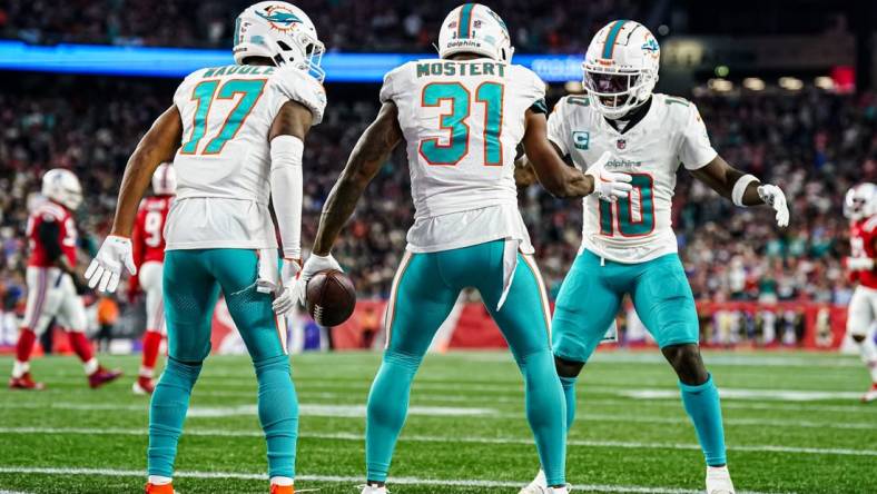 Sep 17, 2023; Foxborough, Massachusetts, USA; Miami Dolphins running back Raheem Mostert (31) celebrates with wide receiver Tyreek Hill (10) and wide receiver Jaylen Waddle (17) after scoring against the New England Patriots in the second quarter at Gillette Stadium. Mandatory Credit: David Butler II-USA TODAY Sports