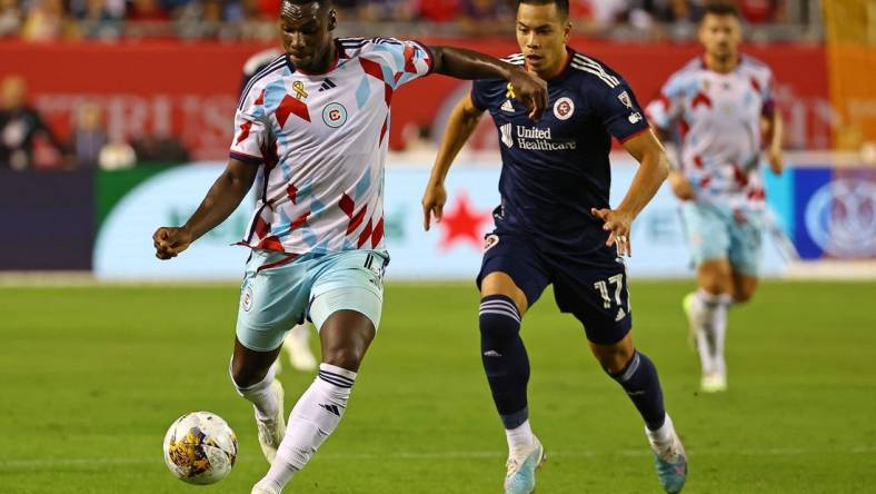 Sep 23, 2023; Chicago, Illinois, USA; Chicago Fire defender Carlos Teran (4) steals the ball from New England Revolution forward Bobby Wood (17) from during the second half at Soldier Field. Mandatory Credit: Mike Dinovo-USA TODAY Sports