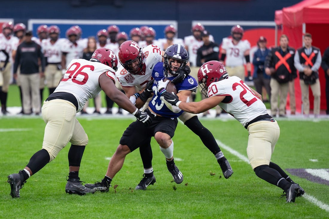 Holy Cross's Jordan Fuller is tackled by a wall of Harvard defenders during Saturday's EBW Football Classic at Polar Park.