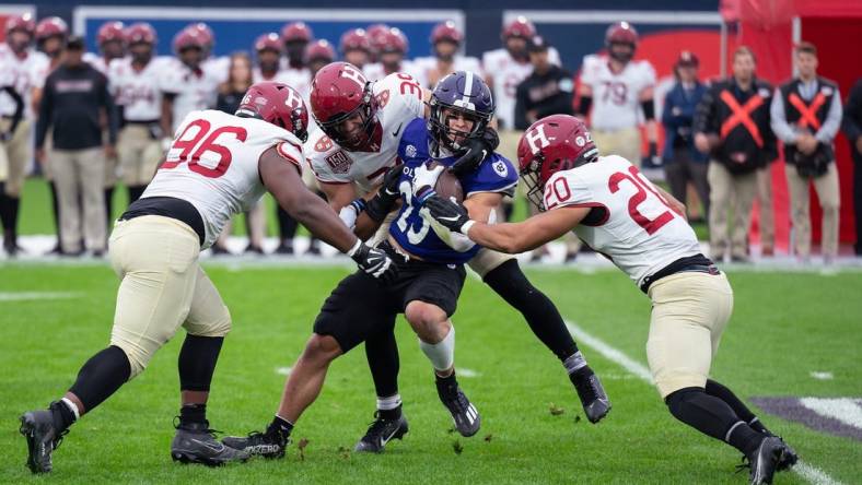 Holy Cross's Jordan Fuller is tackled by a wall of Harvard defenders during Saturday's EBW Football Classic at Polar Park.