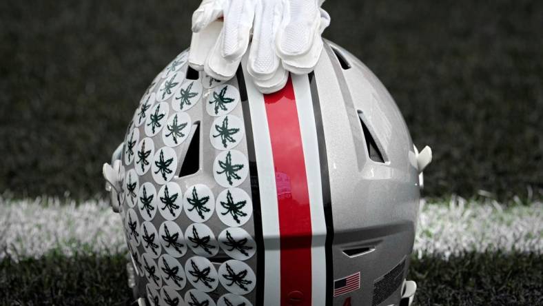 Oct. 14, 2023; Lafayette, In., USA; 
Gloves lie on top of the helmet of Ohio State Buckeyes wide receiver Julian Fleming (4) before Saturday's NCAA Division I football game against the Purdue Boilermakers at Ross-Ade Stadium in Lafayette.