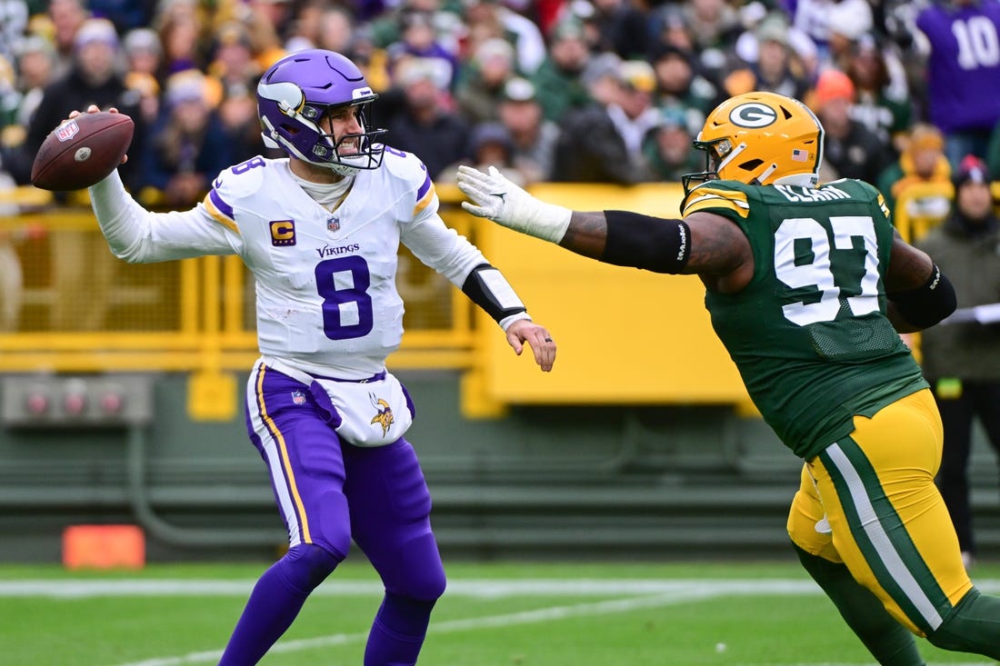 Oct 29, 2023; Green Bay, Wisconsin, USA; Minnesota Vikings quarterback Kirk Cousins (8) gets pressure from Green Bay Packers linebacker Kenny Clark (97) in the first quarter at Lambeau Field. Mandatory Credit: Benny Sieu-USA TODAY Sports