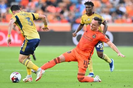 Oct 29, 2023; Houston, TX, USA; Houston Dynamo forward Corey Baird (11) kicks the bal from Real Salt Lake defender Bryan Oviedo (3) in the first half for game one in a round one match of the 2023 MLS Cup Playoffs at Shell Energy Stadium. Mandatory Credit: Maria Lysaker-USA TODAY Sports