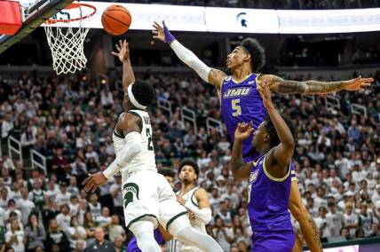 Michigan State's Tyson Walker, left, scores as James Madison's Terrence Edwards, Jr. defends during the second half on Monday, Nov. 6, 2023, in East Lansing.