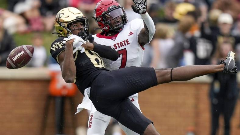 Nov 11, 2023; Winston-Salem, North Carolina, USA; Wake Forest Demon Deacons running back Justice Ellison (6) loses the ball defended by North Carolina State Wolfpack cornerback Shyheim Battle (7) during the first half at Allegacy Federal Credit Union Stadium. Mandatory Credit: Jim Dedmon-USA TODAY Sports