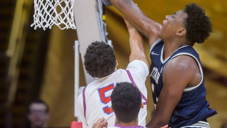 Utah State's Great Osobor, right, slam dunks over Bradley's Christian Davis in the second half of the Braves' home opener Saturday, Nov. 11, 2023 at Carver Arena.