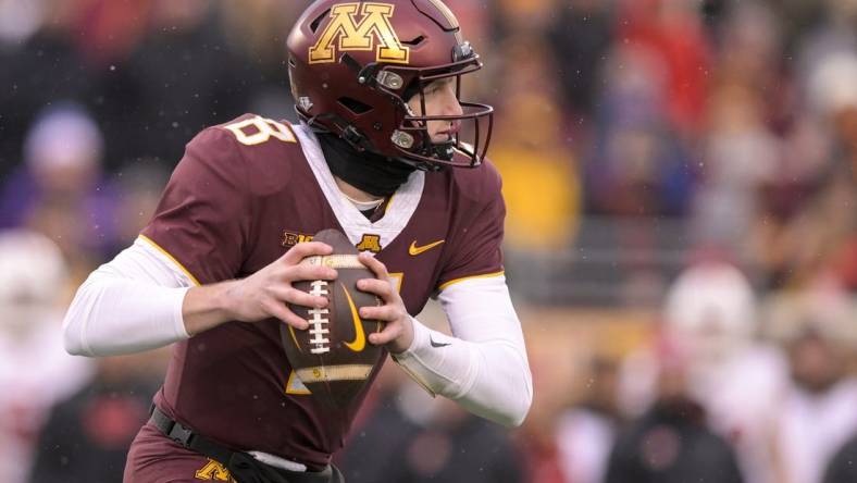 Nov 25, 2023; Minneapolis, Minnesota, USA;  Minnesota Golden Gophers quarterback Athan Kaliakmanis (8) scrambles out of the pocket against the Wisconsin Badgers during the second quarter at Huntington Bank Stadium. Mandatory Credit: Nick Wosika-USA TODAY Sports