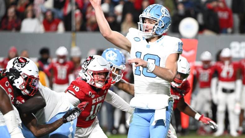 Nov 25, 2023; Raleigh, North Carolina, USA; North Carolina Tar Heels quarterback Drake Maye (10) throws a pass against North Carolina State Wolfpack linebacker Caden Fordham during the first half at Carter-Finley Stadium. Mandatory Credit: Rob Kinnan-USA TODAY Sports