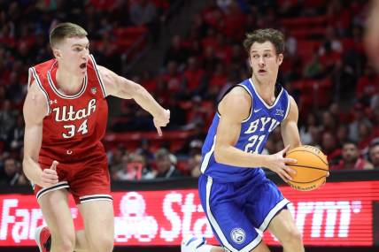 Dec 9, 2023; Salt Lake City, Utah, USA; Brigham Young Cougars guard Trevin Knell (21) dribble past Utah Utes center Lawson Lovering (34) during the first half at Jon M. Huntsman Center. Mandatory Credit: Rob Gray-USA TODAY Sports