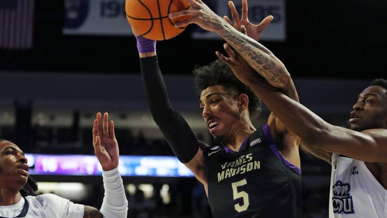 Dec 9, 2023; Norfolk, Virginia, USA; James Madison Dukes guard Terrence Edwards (5) drives to the basket against Old Dominion Monarchs guard Chaunce Jenkins (2) guard R.J. Blakney (15) at Chartway Arena at the Ted Constant Convocation Center. Mandatory Credit: Peter Casey-USA TODAY Sports