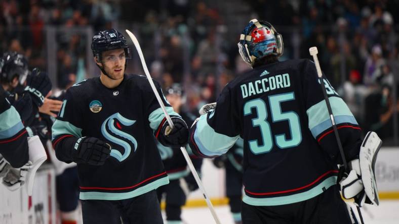 Dec 12, 2023; Seattle, Washington, USA; Seattle Kraken center Alex Wennberg (21) and goaltender Joey Daccord (35) celebrate after Wennberg scored a goal against the Florida Panthers during the third period at Climate Pledge Arena. Mandatory Credit: Steven Bisig-USA TODAY Sports