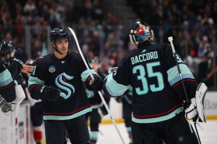 Dec 12, 2023; Seattle, Washington, USA; Seattle Kraken center Alex Wennberg (21) and goaltender Joey Daccord (35) celebrate after Wennberg scored a goal against the Florida Panthers during the third period at Climate Pledge Arena. Mandatory Credit: Steven Bisig-USA TODAY Sports