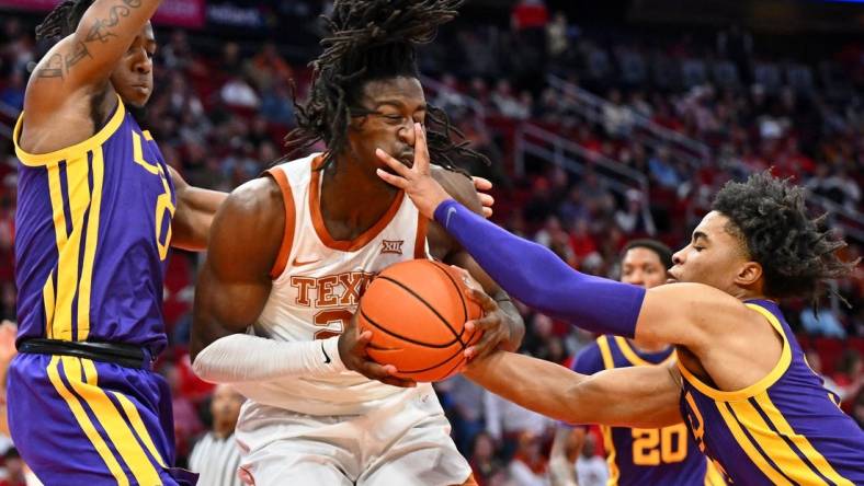 Dec 16, 2023; Houston, Texas, USA; Texas Longhorns forward Ze'Rik Onyema (21) battles for the ball against LSU Tigers guard Trae Hannibal (left) and guard Jalen Cook (right) during the first half at Toyota Center. Mandatory Credit: Maria Lysaker-USA TODAY Sports