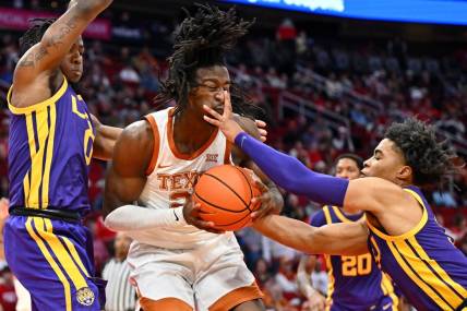 Dec 16, 2023; Houston, Texas, USA; Texas Longhorns forward Ze'Rik Onyema (21) battles for the ball against LSU Tigers guard Trae Hannibal (left) and guard Jalen Cook (right) during the first half at Toyota Center. Mandatory Credit: Maria Lysaker-USA TODAY Sports