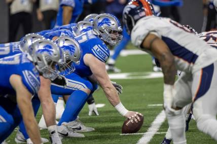 Dec 16, 2023; Detroit, Michigan, USA; Detroit Lions center Frank Ragnow (77) gets ready to snap the ball in the first half against the Denver Broncos at Ford Field. Mandatory Credit: David Reginek-USA TODAY Sports