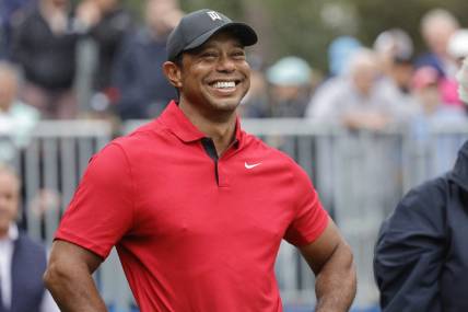 Dec 17, 2023; Orlando, Florida, USA;  Tiger Woods smiles before he plays his shot from the first tee during the PNC Championship at The Ritz-Carlton Golf Club. Mandatory Credit: Reinhold Matay-USA TODAY Sports