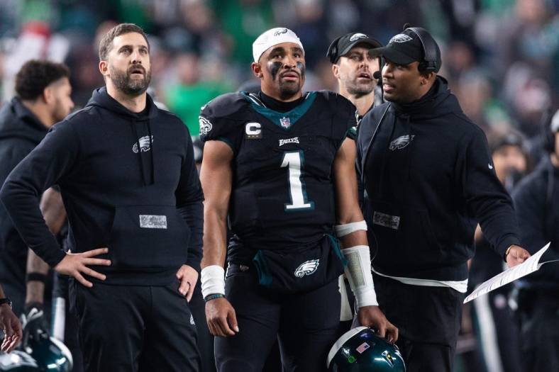 Dec 25, 2023; Philadelphia, Pennsylvania, USA; Philadelphia Eagles head coach Nick Sirianni (L) and quarterback Jalen Hurts (1) and offensive coordinator Brian Johnson (R) talk during the second quarter against the New York Giants at Lincoln Financial Field. Mandatory Credit: Bill Streicher-USA TODAY Sports