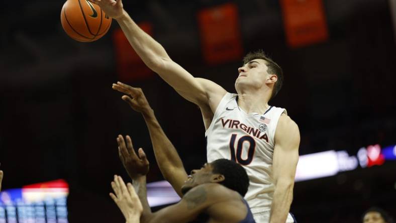 Dec 27, 2023; Charlottesville, Virginia, USA; Virginia Cavaliers guard Taine Murray (10) blocks the shot of Morgan State Bears guard Amahrie Simpkins (11) in the first half at John Paul Jones Arena. Mandatory Credit: Geoff Burke-USA TODAY Sports