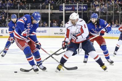 Dec 27, 2023; New York, New York, USA; New York Rangers defenseman K'Andre Miller (79) and Washington Capitals left wing Alex Ovechkin (8) battle for control of the puck in the third period at Madison Square Garden. Mandatory Credit: Wendell Cruz-USA TODAY Sports