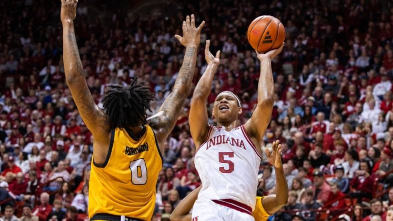 Dec 29, 2023; Bloomington, Indiana, USA; Indiana Hoosiers forward Malik Reneau (5) shoots the ball while Kennesaw State Owls forward Demond Robinson (0) and  guard Terrell Burden (1) defend in the first half at Simon Skjodt Assembly Hall. Mandatory Credit: Trevor Ruszkowski-USA TODAY Sports