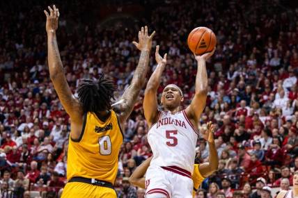 Dec 29, 2023; Bloomington, Indiana, USA; Indiana Hoosiers forward Malik Reneau (5) shoots the ball while Kennesaw State Owls forward Demond Robinson (0) and  guard Terrell Burden (1) defend in the first half at Simon Skjodt Assembly Hall. Mandatory Credit: Trevor Ruszkowski-USA TODAY Sports