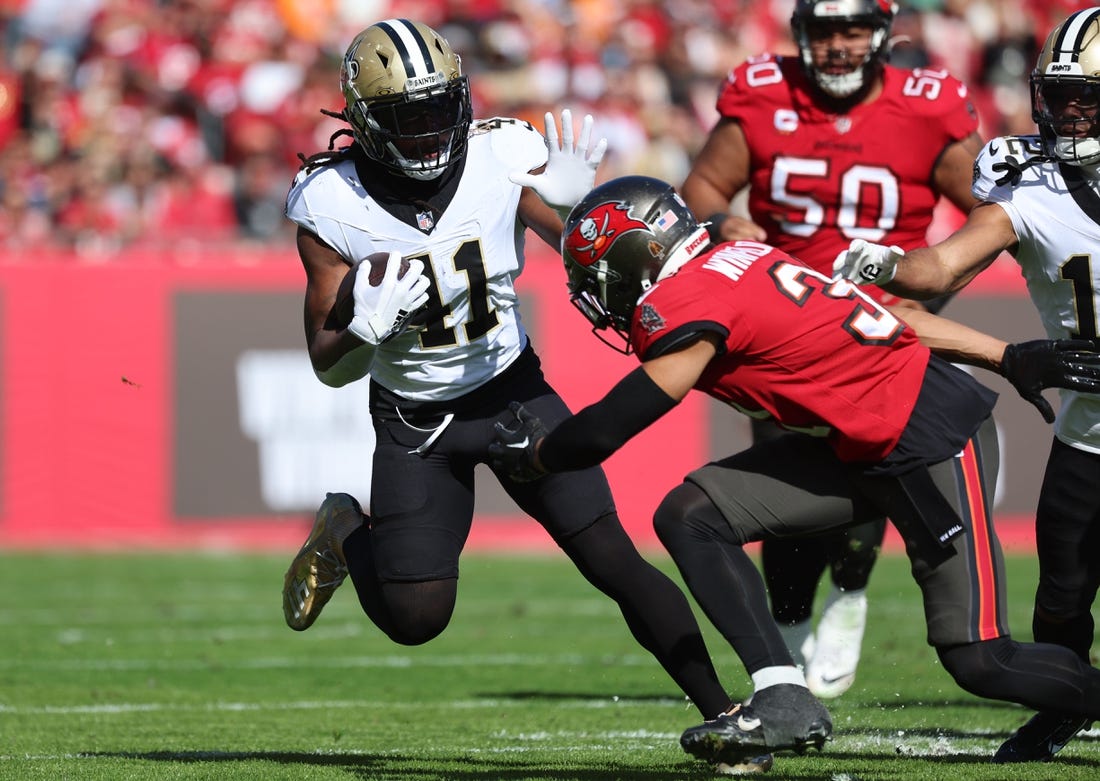 Dec 31, 2023; Tampa, Florida, USA;New Orleans Saints running back Alvin Kamara (41) stiff arms Tampa Bay Buccaneers safety Antoine Winfield Jr. (31) during the first quarter at Raymond James Stadium. Mandatory Credit: Kim Klement Neitzel-USA TODAY Sports