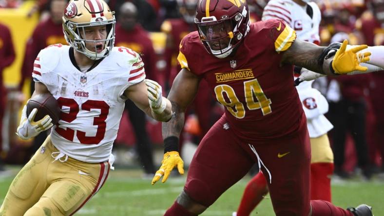 Dec 31, 2023; Landover, Maryland, USA; San Francisco 49ers running back Christian McCaffrey (23) carries the ball as Washington Commanders defensive tackle Daron Payne (94) during the second half at FedExField. Mandatory Credit: Brad Mills-USA TODAY Sports