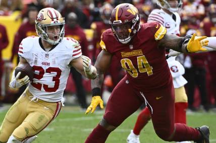 Dec 31, 2023; Landover, Maryland, USA; San Francisco 49ers running back Christian McCaffrey (23) carries the ball as Washington Commanders defensive tackle Daron Payne (94) during the second half at FedExField. Mandatory Credit: Brad Mills-USA TODAY Sports