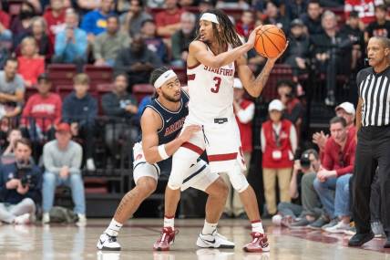 Dec 31, 2023; Stanford, California, USA; Stanford Cardinal guard Kanaan Carlyle (3) keeps the ball away from Arizona Wildcats guard Kylan Boswell (4) during the second half at Maples Pavilion. Mandatory Credit: Stan Szeto-USA TODAY Sports