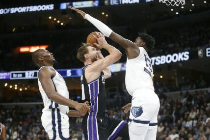 Dec 31, 2023; Memphis, Tennessee, USA; Sacramento Kings forward Domantas Sabonis (10) drives to the basket between Memphis Grizzlies center Bismack Biyombo (18) and forward-center Jaren Jackson Jr. (13) during the first half at FedExForum. Mandatory Credit: Petre Thomas-USA TODAY Sports