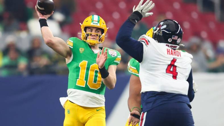 Jan 1, 2024; Glendale, AZ, USA; Oregon Ducks quarterback Bo Nix (10) throws the ball under pressure from Liberty Flames defensive tackle Jay Hardy (4) during the first quarter of the 2024 Fiesta Bowl at State Farm Stadium. Mandatory Credit: Mark J. Rebilas-USA TODAY Sports