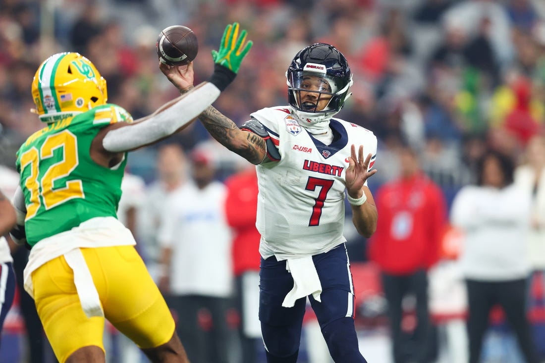 Jan 1, 2024; Glendale, AZ, USA; Liberty Flames quarterback Kaidon Salter (7) throws the ball under pressure from Oregon Ducks linebacker Emar'rion Winston (32) during the second half in the 2024 Fiesta Bowl at State Farm Stadium. Mandatory Credit: Mark J. Rebilas-USA TODAY Sports