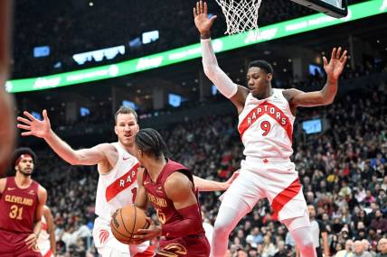 Jan 1, 2024; Toronto, Ontario, CAN; Toronto Raptors center Jakob Poeltl (19) and forward RJ Barrett (9) defend their basket as Cleveland Cavaliers guard Isaac Okoro (35) looks to make a pass in the first half at Scotiabank Arena. Mandatory Credit: Dan Hamilton-USA TODAY Sports