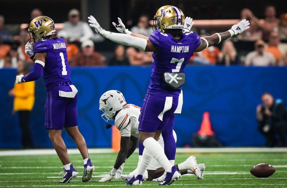 Texas Longhorns wide receiver Xavier Worthy (1) remains on the ground at the Washington Huskies defense, including cornerback Dominique Hampton (7) celebrate stopping a play in the second quarter of the Sugar Bowl College Football Playoff semi-finals at the Ceasars Superdome in New Orleans, Louisiana, Jan. 1, 2024. The Texas Longhorns take on the Washington Huskies for a spot in the College Football Playoff Finals.