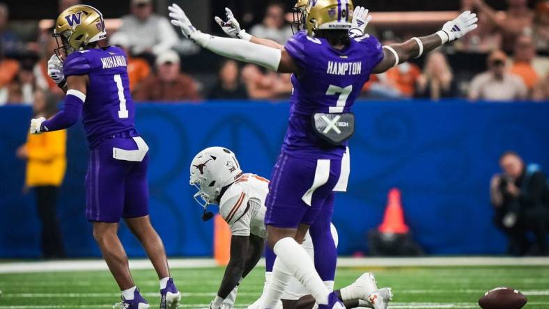 Texas Longhorns wide receiver Xavier Worthy (1) remains on the ground at the Washington Huskies defense, including cornerback Dominique Hampton (7) celebrate stopping a play in the second quarter of the Sugar Bowl College Football Playoff semi-finals at the Ceasars Superdome in New Orleans, Louisiana, Jan. 1, 2024. The Texas Longhorns take on the Washington Huskies for a spot in the College Football Playoff Finals.