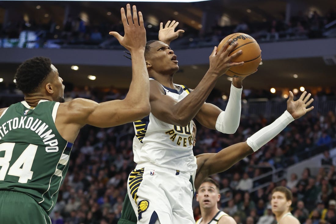 Jan 1, 2024; Milwaukee, Wisconsin, USA; Indiana Pacers guard Bennedict Mathurin (00) goes to the basket against Milwaukee Bucks forward Giannis Antetokounmpo (34) during the second half at Fiserv Forum. Mandatory Credit: Kamil Krzaczynski-USA TODAY Sports