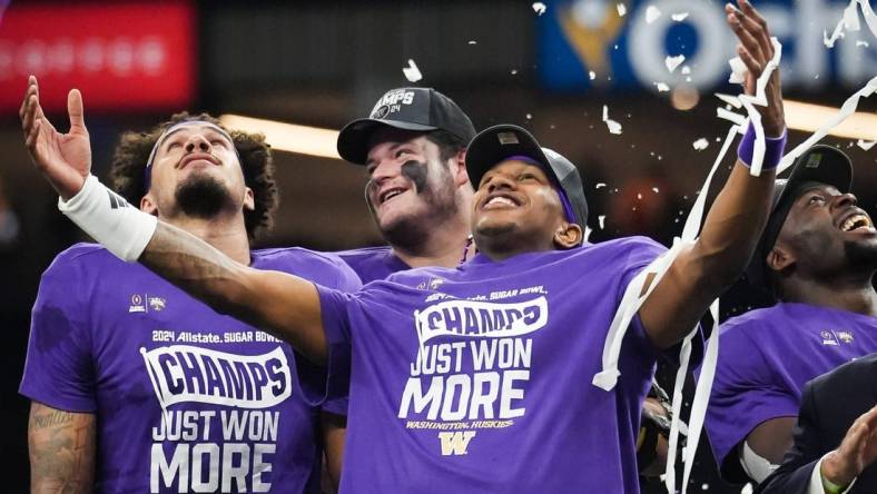 Washington Huskies quarterback Michael Penix Jr. (9), center, and his teammates watch as confetti begins to fall after winning the Sugar Bowl College Football Playoff semi-finals at the Ceasars Superdome in New Orleans, Louisiana, Jan. 1, 2024. The Huskies won the game over the Texas Longhorns 37-31.