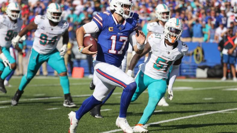 Bills quarterback Josh Allen tucks the ball and scores a touchdown against the Dolphins.